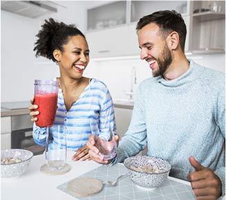 Un homme et une femme souriant dans la cuisine